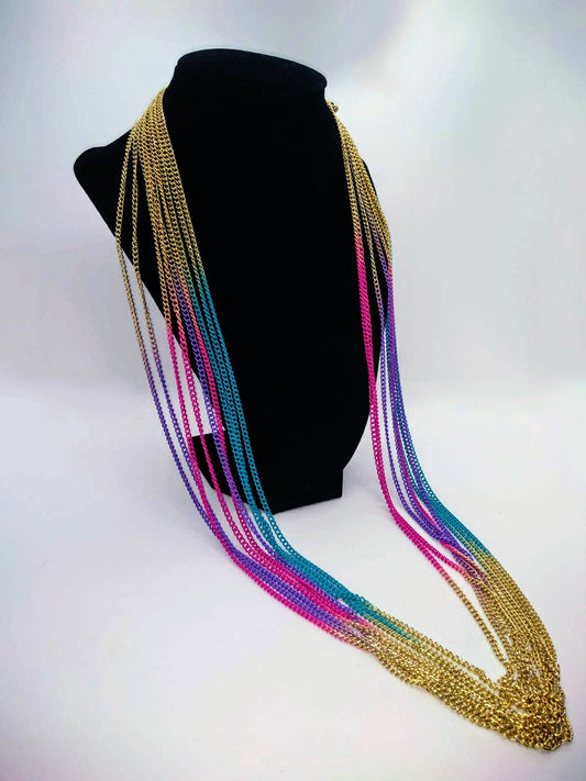 gold multi strand necklace with purple, turquoise, and pink accents draped on black stand