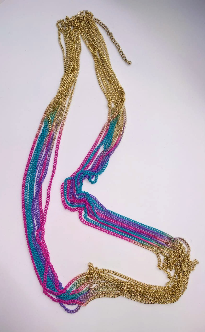 multicolored gold chain necklace draped on white background