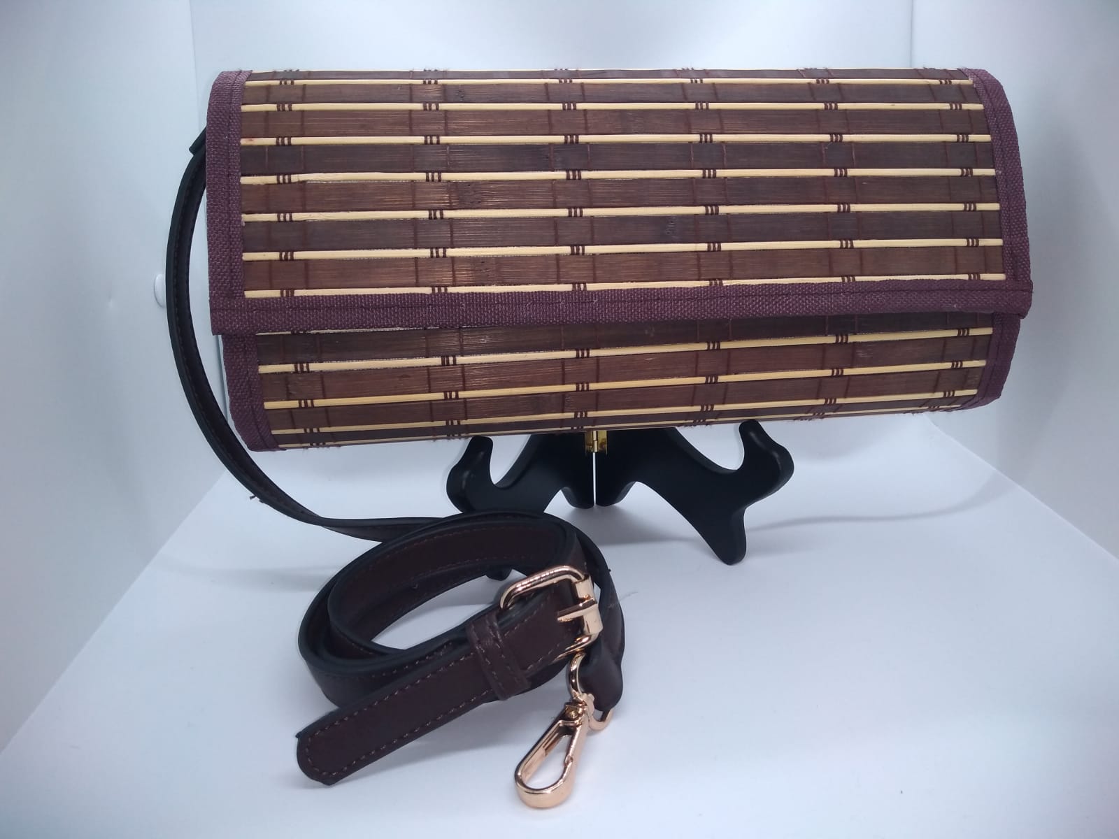 brown and purple clutch front view with deep brown shoulder strap with gold hardware.