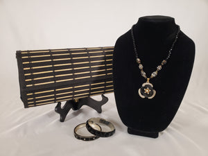 Black wood clutch displayed with rhinestone jewelry.