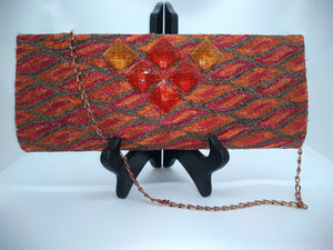 Orange clutch with chain strap and square orange beads on stand